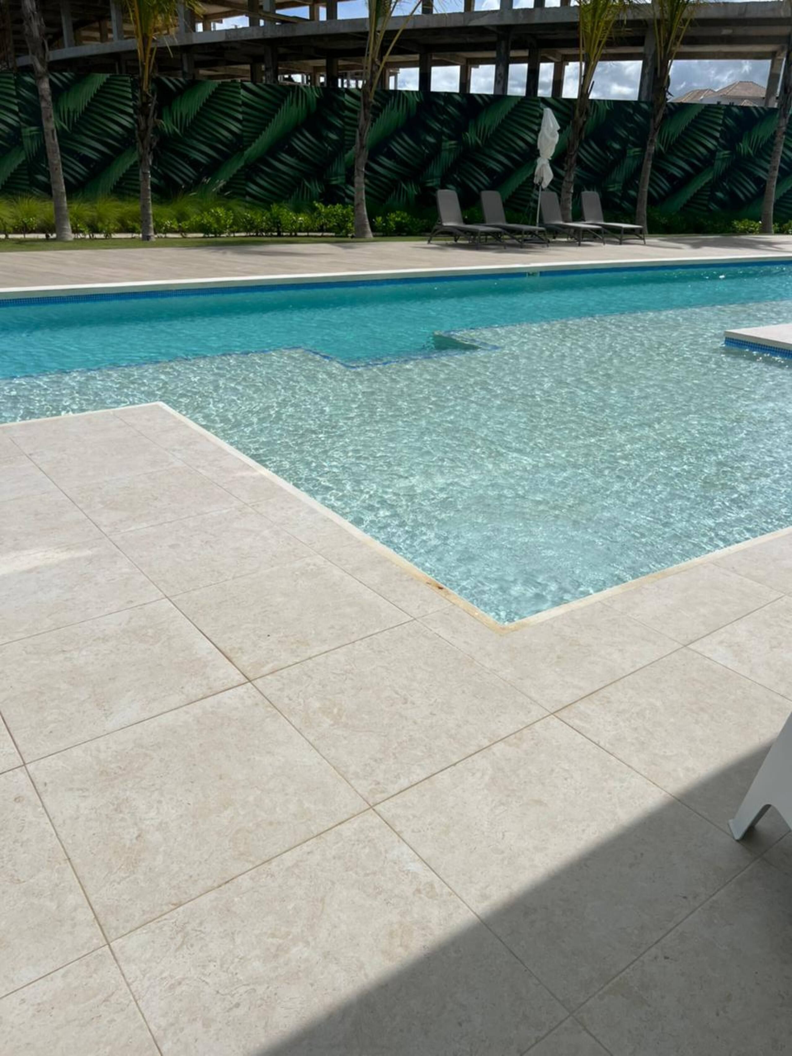 Baldosas de la terraza junto al borde de la piscina, a un paso del agua